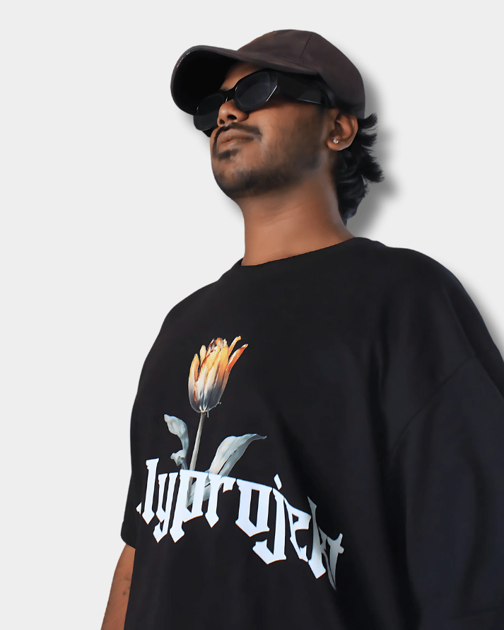 Man wearing black Daydream Bloom oversized t-shirt with floral graphic and Gully Projekt logo