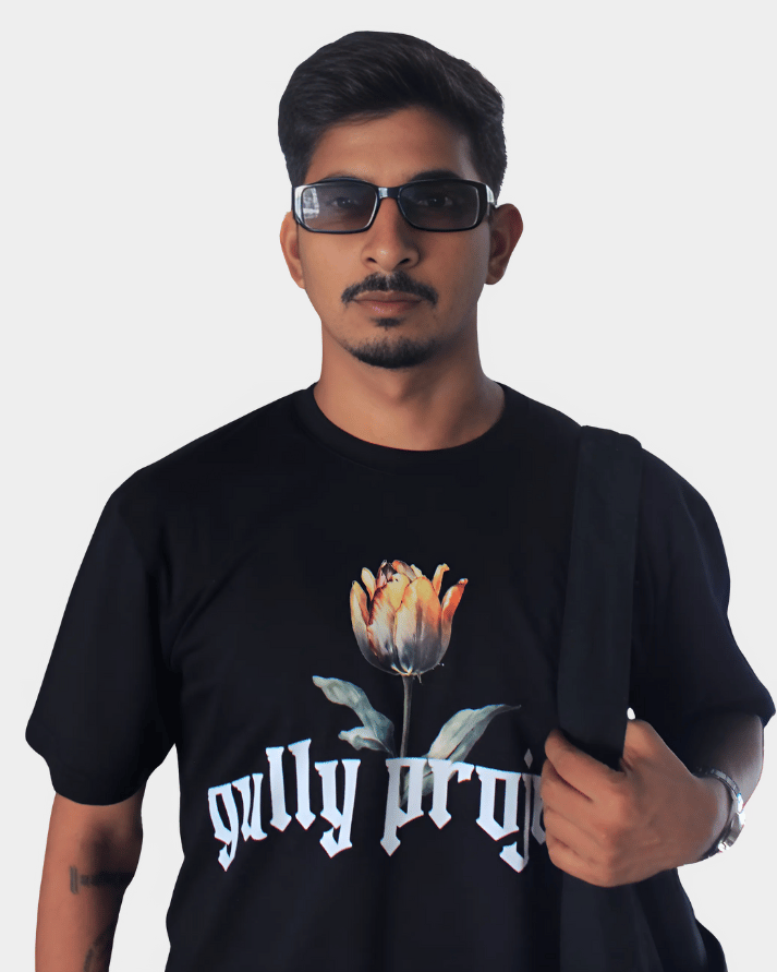 Man wearing black Daydream Bloom oversized t-shirt with floral graphic and gully projekt text