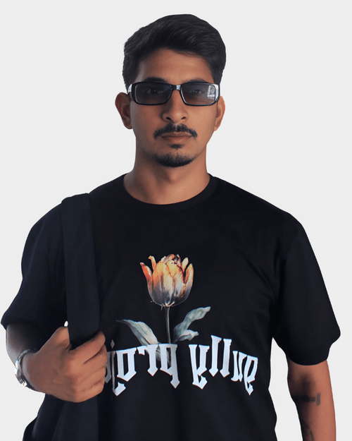 Man wearing black Daydream Bloom oversized t-shirt with floral design and serif text