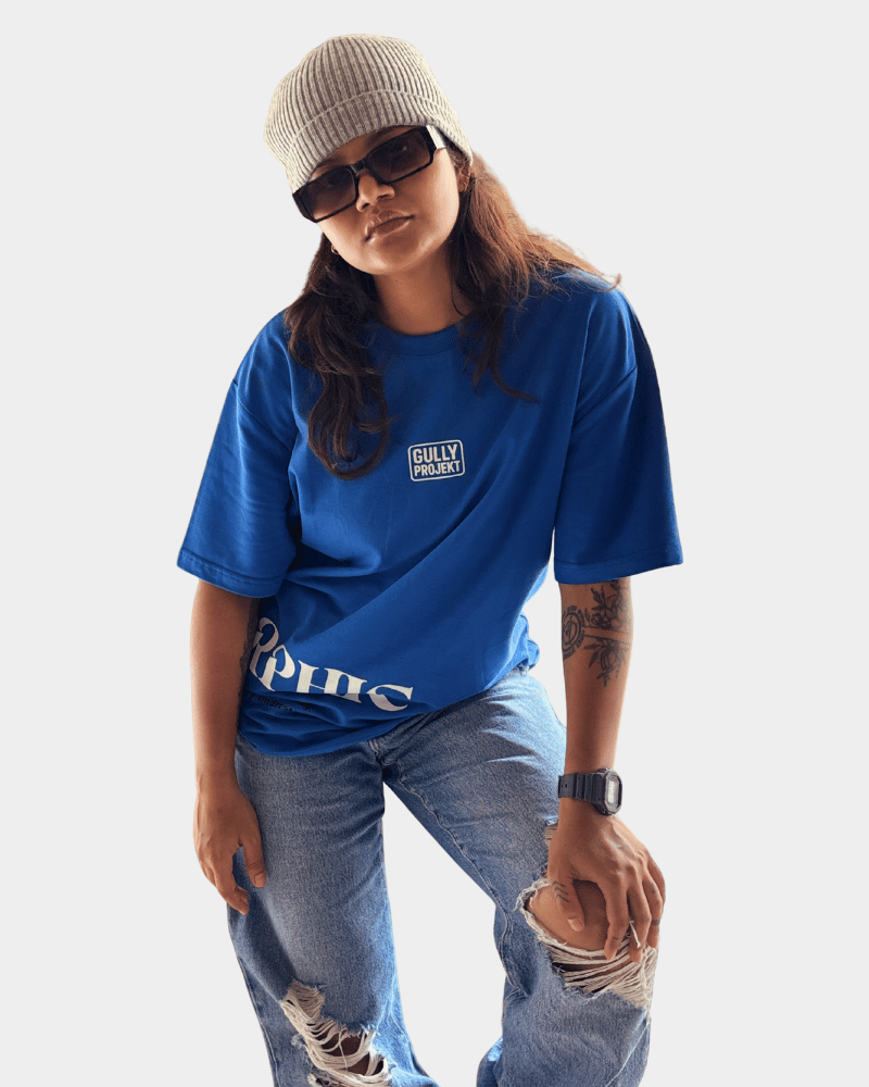 Woman wearing a blue premium urban oversized t-shirt by Gully Projekt styled with ripped jeans and a beanie