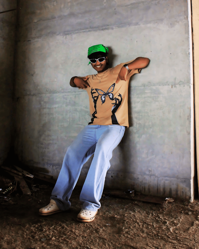 Man wearing Gully Projekt tainted flight graphic t-shirt with light blue jeans and green headwear